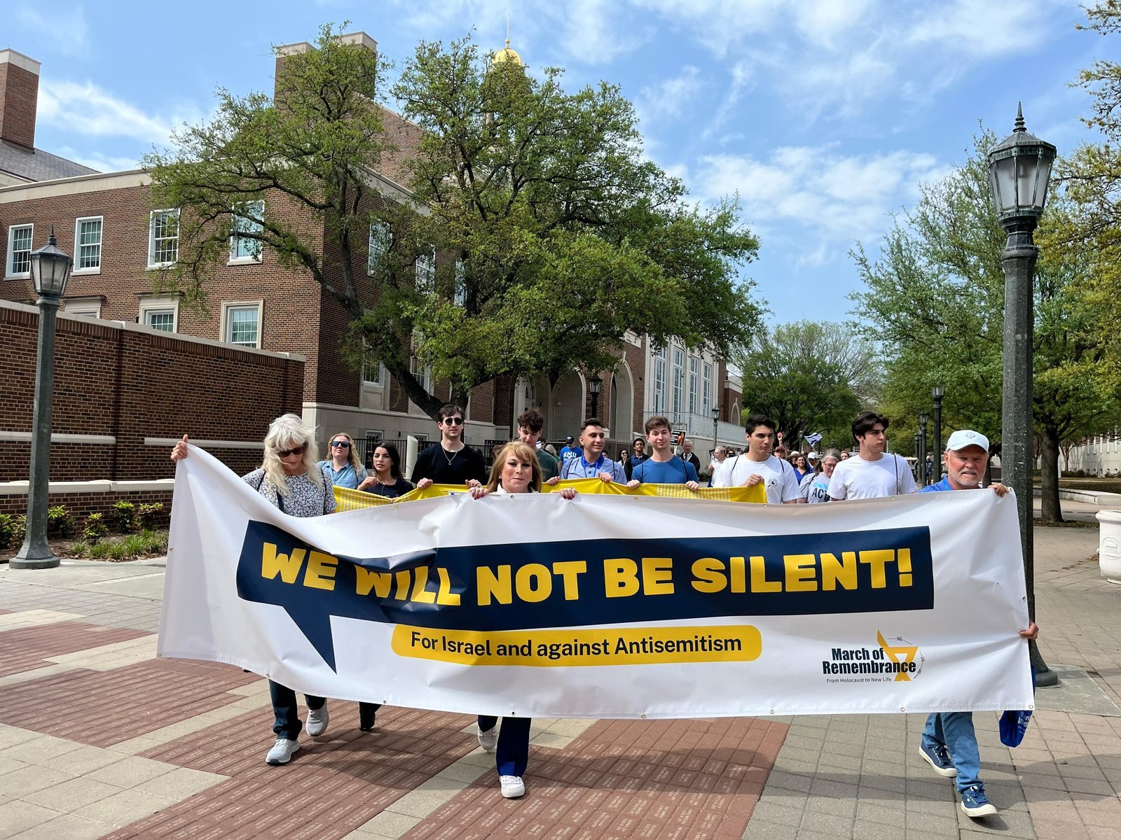 Marchers holding a 'We will not be silent' banner for Israel and against antisemitism at a March of Life event